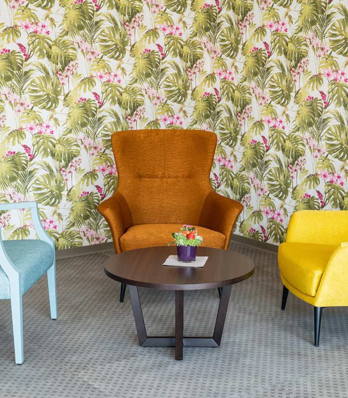 Bunte Sessel in der Aufenhaltsecke mit floraler Tapete in Blumberg